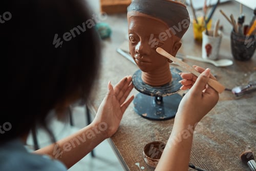 Preview: Female ceramic artist working with clay sculpture in workshop