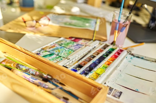 Preview: Watercolor drawing, glasses, watercolors in a box, brushes on the table, nobody