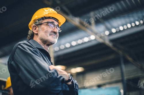 Preview: Senior high skill professional engineer male worker in heavy industry factory standing confident.