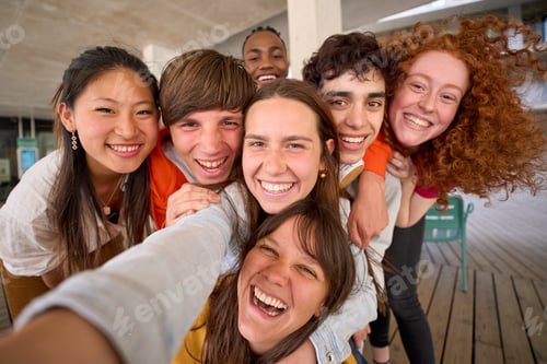 Preview: Smiling group multi-ethnic students posing for selfie mobile phone gathered on college campus.