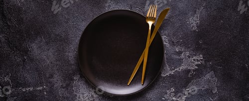 Preview: Clean empty black plate with cutlery.