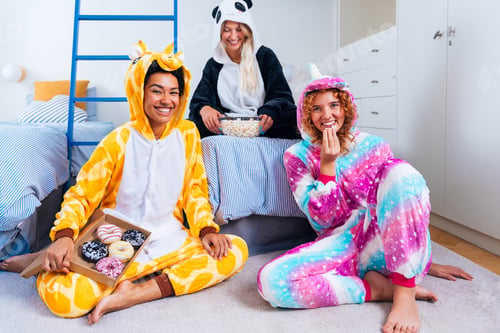 Preview: Multiethnic group of young female friends having pajamas party at home