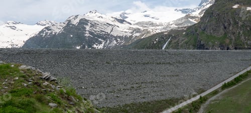 Preview: Scenic view of a rocky landscape with snowy mountains in the background