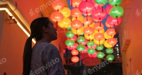 Preview: Woman look at the chinese traditional lantern hanging at outdoor in the evening