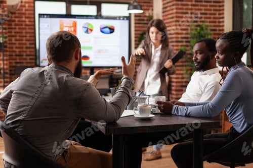Preview: Businesswoman discussing project ideas pointing at monitor