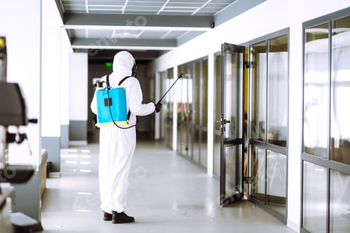 Preview: Disinfecting of office to prevent COVID-19, Man in protective hazmat suit with spray chemicals.