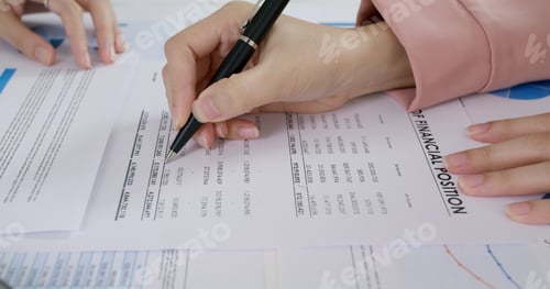 Preview: Close-up people hand of female stock trader use pen write on tax plan paper