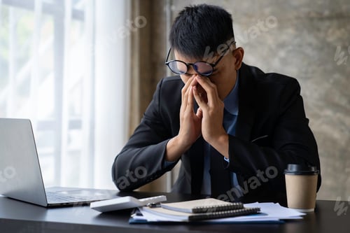 Preview: tired businessman sleepy and bored from sitting at a desk for a long time and has office syndrome