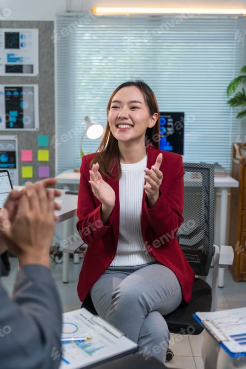 Preview: Businesswoman clapping hands celebrating business success during a meeting
