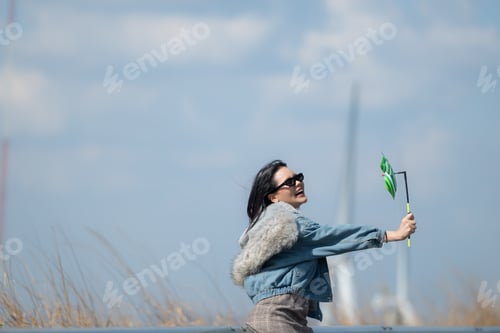 Preview: Young gorgeous brunette woman with long hair wearing a blue jacket, black sunglasses