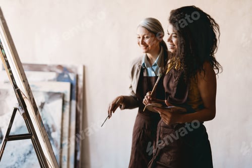 Preview: Mature teacher talking with her student during class in art school