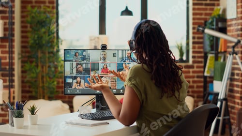 Preview: Female employee attending remote videocall meeting on webcam