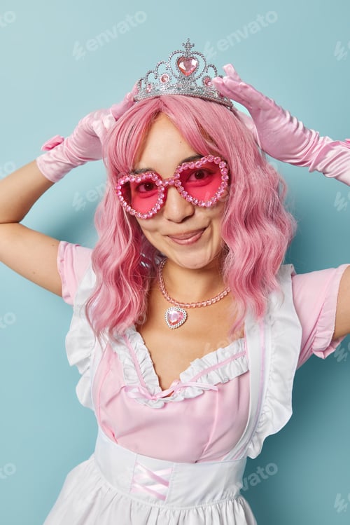 Preview: Vertical shot of good looking Asian woman prepares for masquerade puts on crown on head dressed like