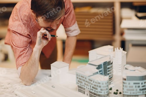 Preview: Architect with blueprints and layout design building house city project in office bureau