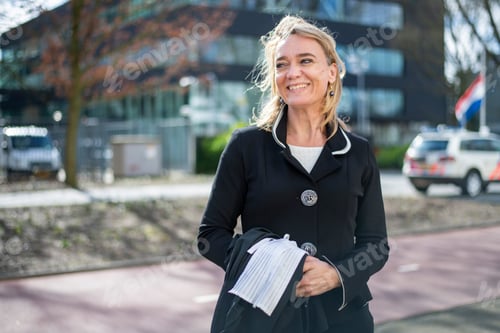 Preview: Young professional woman standing in public smiling happy walking to work