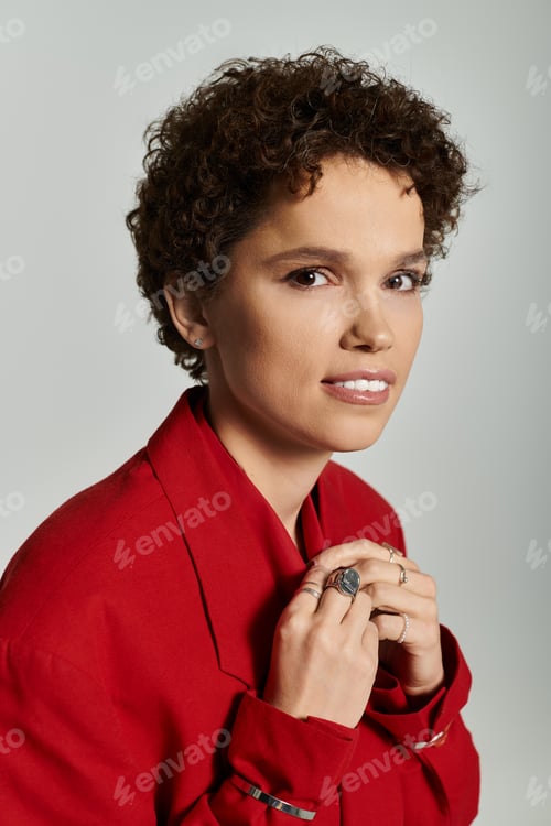 Preview: Young beautiful woman showcasing fashion in a vibrant red outfit against a minimalist backdrop