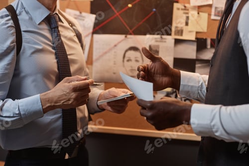 Preview: Close up of two unrecognizable detectives discussing case during investigation