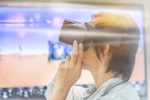 Preview: Young woman with short hair using virtual reality goggles. Concept of modern technologies.