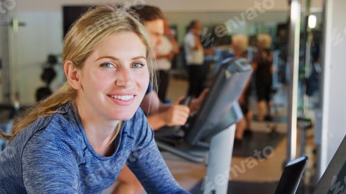 Preview: Portrait Of Active Woman Resting After Exercising On Cycling Machines In Gym