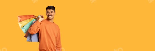 Preview: Guy with shopping bags smiles happily on yellow