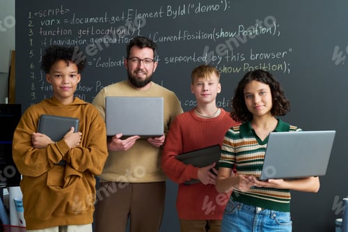Preview: Diverse Group of Teenagers and Caucasian Man Holding Laptops Collaborating
