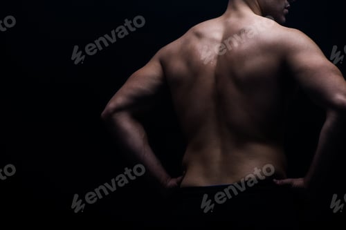 Preview: partial view of sexy bodybuilder with muscular back posing isolated on black