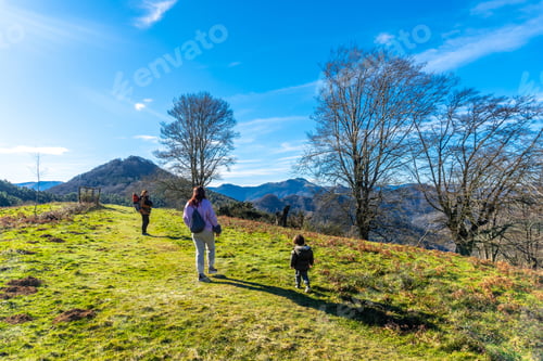 Preview: A group of people are walking on a grassy hillside
