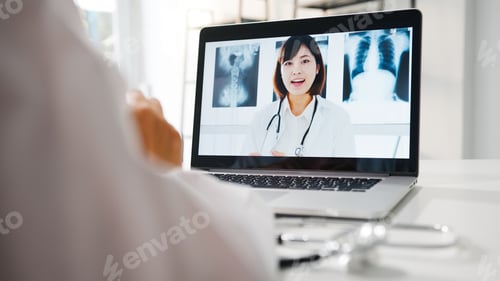 Preview: Young Asia female doctor using laptop talking video conference call with senior doctor at hospital.