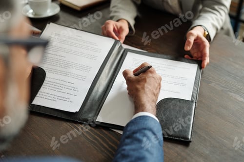 Preview: Middle Aged Caucasian Man Signing Contract with Businesswoman during Meeting