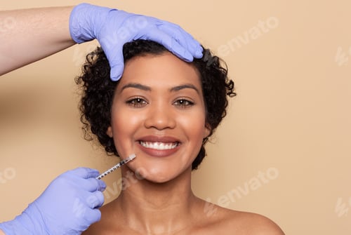 Preview: Woman receives cosmetic injection in a beauty clinic during daylight hours