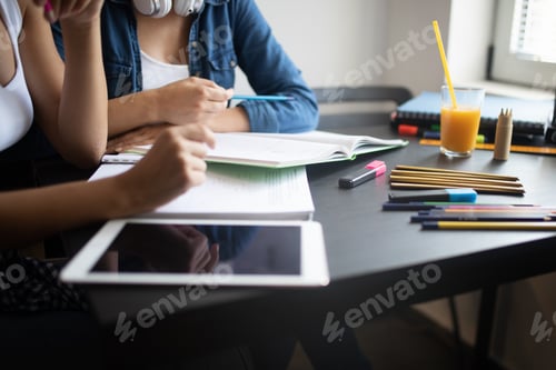 Preview: Happy university friends studying together in college