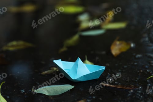 Preview: Paper boat in puddle outdoor in rainy weather