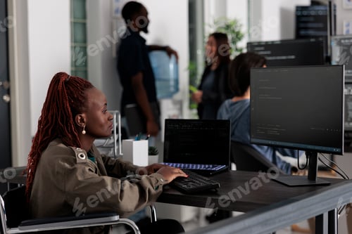 Preview: Programmer in wheelchiar typing html code on computer
