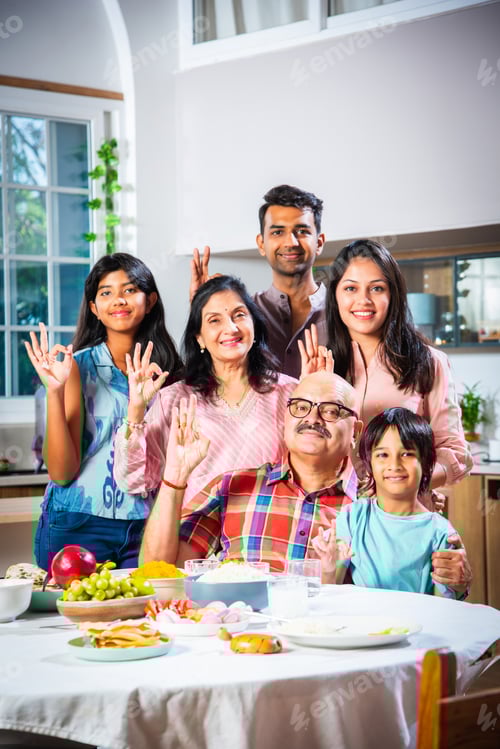 Preview: Happy Indian asian family having lunch at home and posing for photo