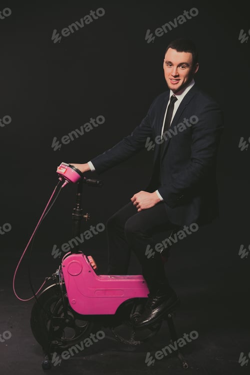 Preview: Model. A Man In A Business Suit Pedaling On A Stationary Bike.