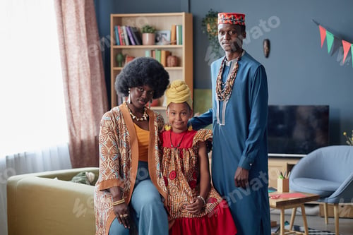 Preview: Black Family Celebrating Kwanzaa with Young Girl Smiling in Living Room