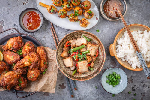 Preview: Assortment of Asian street food, stir fry with vegetables, chicken wings, meat balls and rice