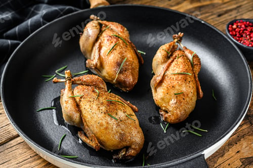 Preview: Homemade roast pigeon quail in a pan. Wooden background. Top view
