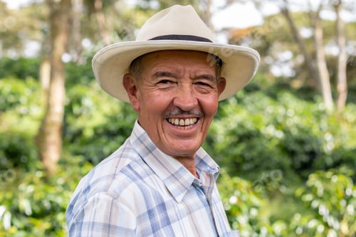 Preview: Portrait of an old Colombian peasant man wearing a hat and looking at the camera with a big smile.