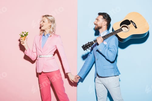 Preview: shocked woman with bouquet and handsome man with acoustic guitar holding hands on pink and blue