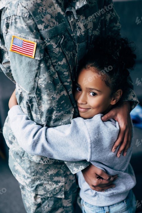 Preview: cropped view of african american daughter hugging female soldier in military uniform at home