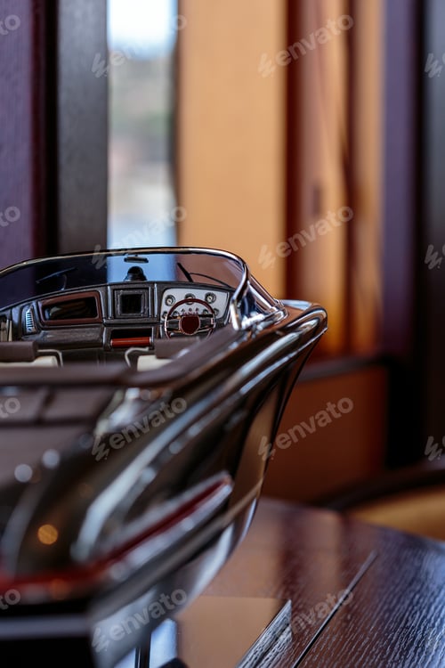 Preview: Vertical closeup shot of a brown yacht figurine on a wooden table