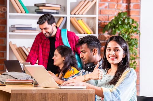 Preview: Indian asian four college or university students using laptop together