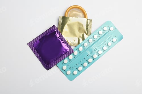 Preview: Condoms and birth control pills on light grey background, flat lay. Safe sex concept