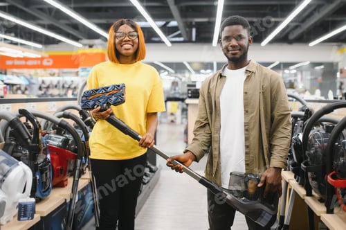 Preview: African american couple crouching and looking at vacuum cleaner they want to buy.