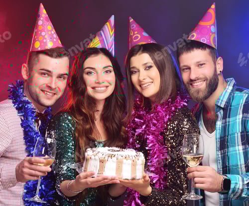 Visualização: amigos em chapéus de festa comemorando um aniversário segurando um bolo e taças de champanhe