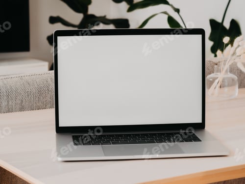 Preview: Laptop with blank screen on wooden table in home interior.