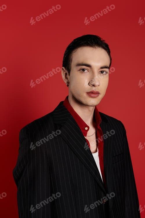 Preview: Elegant Man in Black Suit Against Vibrant Red