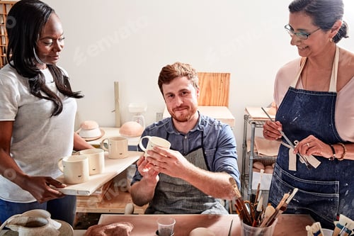 Preview: Group of people painting pottery in workshop