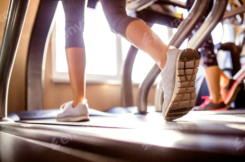 Preview: Detail of legs of woman running on treadmills gym